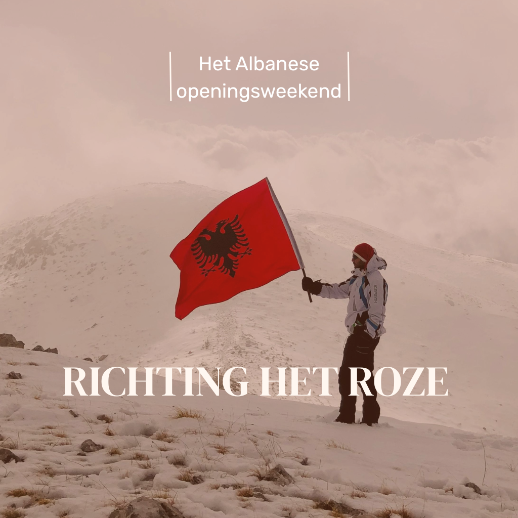 Man in de besneeuwde bergen met de Albanese vlag